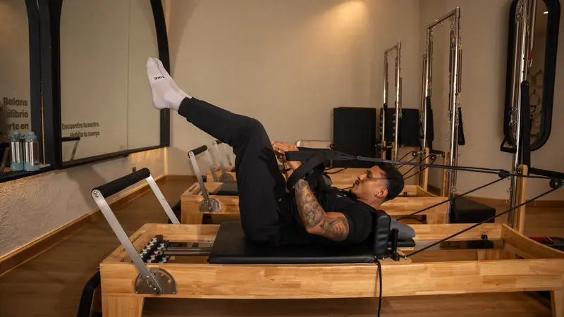 Ejercicio con correas en el reformer durante una clase de Pilates en Balans Studio, Cartagena